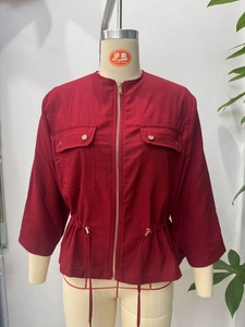 Detail of red stand collar linen jacket with utility flap pockets and gold buttons
