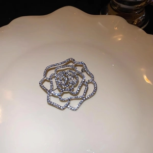 Silver flower brooch with cubic zirconia crystals in hollow rose petal design