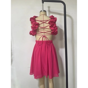 Détail d'une mini robe rose fuchsia avec bretelles croisées dans le dos et des volants
