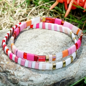 Bohemian two-piece Tila bead elastic bracelet set stacked on natural stone outdoors