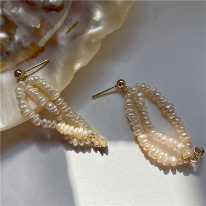 Detailed close-up of Baroque freshwater pearl earrings with double gold hoop layered design