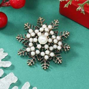 Detailed macro view of a vintage snowflake brooch with pearls and antique gold finish