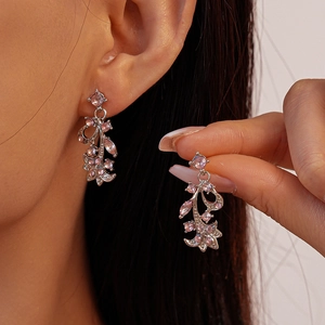 Close-up of pink crystal flower drop earrings with silver metal leaf detailing