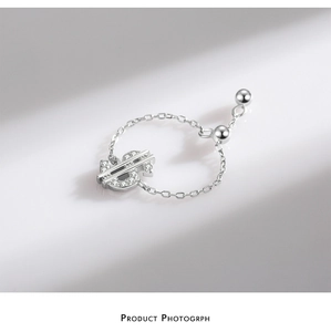 Detailed side view of silver dollar sign ring with sparkling zircons and adjustable chain