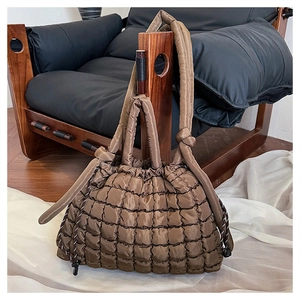 Close-up of brown quilted nylon tote bag featuring a creative knotted shoulder strap detail