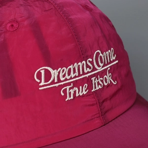 Macro shot of white embroidery on magenta quick-dry baseball cap fabric texture