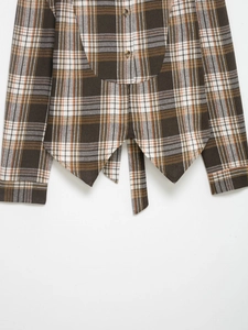 Détail d'une chemise à carreaux vintage avec boutons en bois et ourlet asymétrique