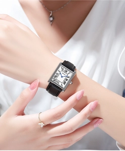 Close-up of rectangle quartz watch with Roman numerals and black leather strap worn on wrist