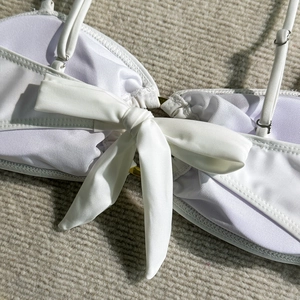 Détails du haut de bikini blanc avec bretelles réglables et nœud au dos sur tissu texturé