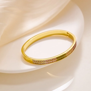 Dettaglio del bracciale dorato aperto con due file di cristalli quadrati colorati