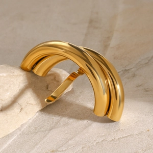 Dettaglio della clip per capelli dorata lucida con archi metallici stratificati