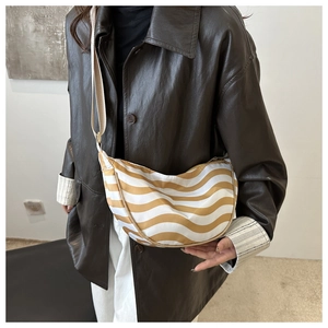 Detail of yellow and white striped nylon crescent bag with adjustable shoulder strap