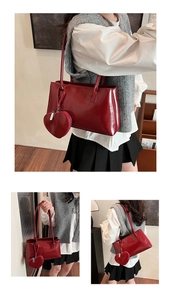 Detail of red patent leather Boston bag with matching heart-shaped coin purse charm