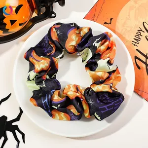 Detail of Halloween hair scrunchie with pumpkin and ghost prints on satin fabric