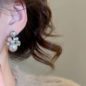 Gros plan d'une boucle d'oreille en perles plaquées or 14 carats avec zircons sur un modèle