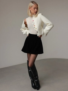 Dettaglio giacca corta in tweed bianco con bordi ondulati e bottoni a cuore colorati
