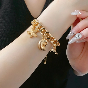 Detailed close-up of golden dolphin, starfish and seashell charms on a stylish link bracelet