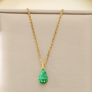 Detailed view of a gold chain necklace featuring a fresh green strawberry fruit pendant
