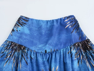 Close-up of elasticated waist and blue leaf print pattern on vacation style skirt