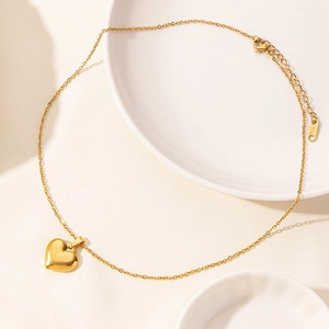 Detailed view of gold heart pendant necklace with S.Steel hallmark on polished chain