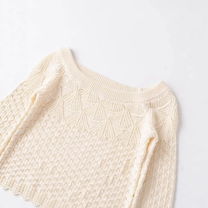 Cream knit sweater with intricate lace hollow-out shoulder detail on white background