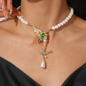 Detail of elegant pearl necklace featuring twin birds and colorful zircon heart pendant