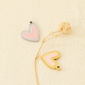 Detail of pink enamel heart pendants in gold and silver finish with beaded edges