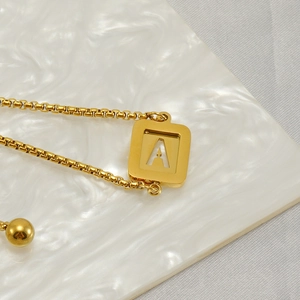 Macro shot of gold square letter A pendant on a stainless steel adjustable box chain