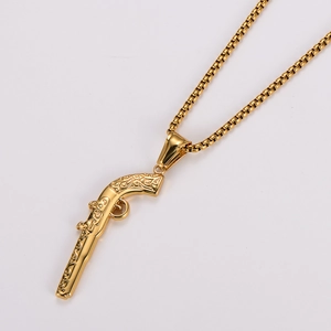 Close-up of a vintage golden pistol pendant necklace with a detailed box chain for men