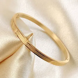 Classic gold stainless steel thin bangle with Greek key pattern on champagne silk