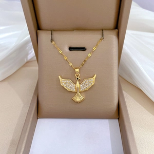 Macro detail of a gold titanium necklace with a crystal-encrusted peace dove pendant