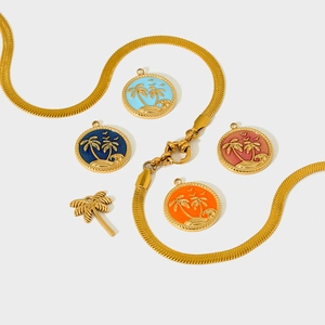 Close-up of colorful enamel palm tree pendants and gold snake chain for jewelry making