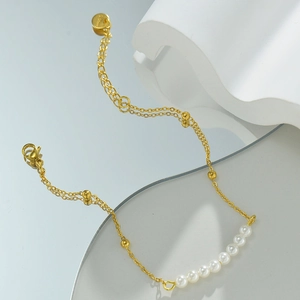 Detailed view of 14k gold-plated chain with white pearls and lobster clasp closure