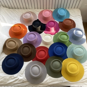 Flat top straw boater hats in multiple vibrant colors arranged on a white background