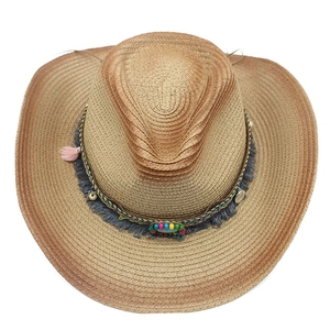 Detail of western straw cowboy hat with bohemian beaded band and colorful tassels