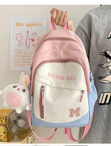 Detail of color-block pink and blue girl backpack with a cute white bunny plush charm