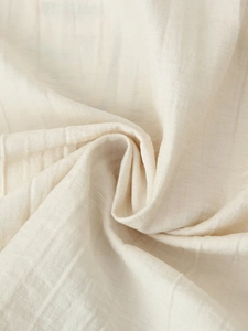 Close-up of beige linen cotton fabric showing natural texture and soft woven fibers