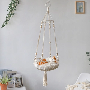 Close-up of handmade macrame cat hammock with woven cotton ropes and decorative tassels