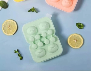 Detail of light green silicone ice mold tray with bear shapes, lemon and mint decor