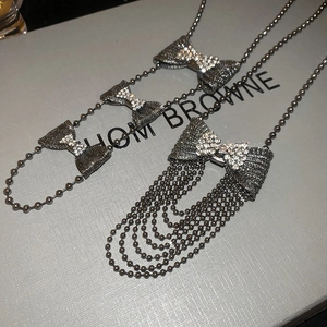 Macro shot of sparkling bow pendant with tassel fringe and gunmetal grey rhinestones