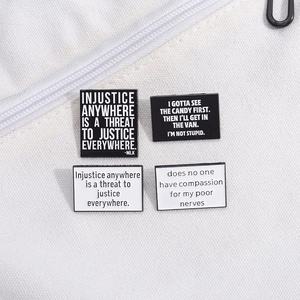 Rectangular enamel pins with inspirational text on a white canvas bag accessory