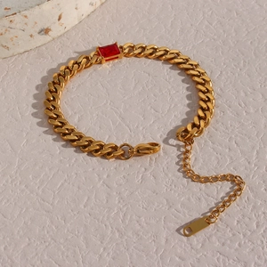 Vista macro di un bracciale a catena cubana dorato con zircone rosso rettangolare