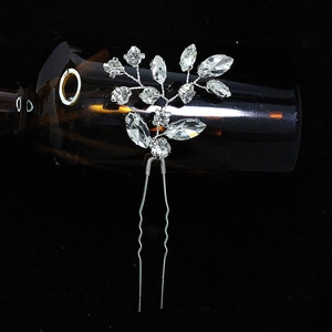 Detailed view of silver bridal hair comb with crystal flowers on dark background