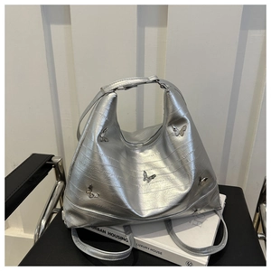 Dettaglio della borsa tote argento motivo anguilla con decorazioni farfalla in metallo