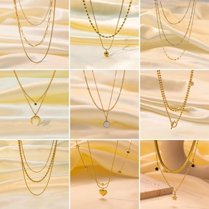 Detail of nine 18K gold plated titanium necklaces with various pendants and chain styles