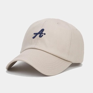 Detailed view of the 3D embroidered blue letter A on a beige cotton baseball cap