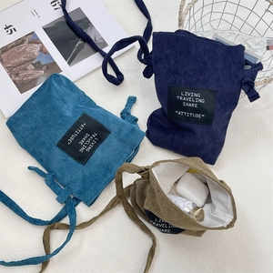 Corduroy mini crossbody bag interior showing storage for earphones and skincare items