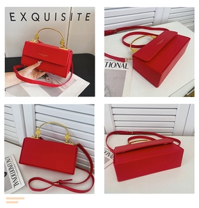Détail du sac à main rouge carré avec poignée en métal doré et bandoulière amovible