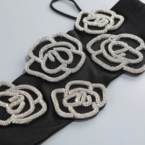 Detail of black satin strap with shimmering silver rhinestone camellia flower charms