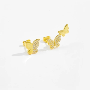 Detailed macro view of asymmetric S925 silver butterfly stud earrings with white zircons